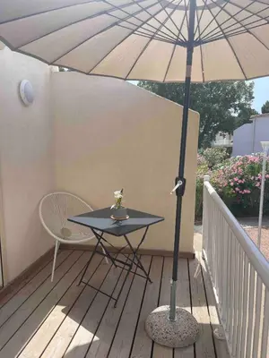 a table with an umbrella on a deck at Studio 47 Cala Rossa Porto Vecchio in Lecci
