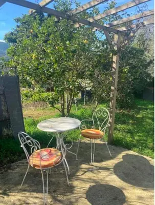 three chairs and a table and a table and chairs under a pergola at Maison individuelle type F2 in Alata