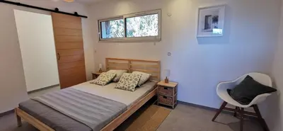 a bedroom with a bed with a chair and a window at Casa FIORI - 2 personnes - Vue mer in Pietrosella