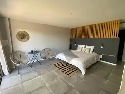 a bedroom with a large bed and two chairs at Palombaggia Camara - Lecci Lodge in Lecci