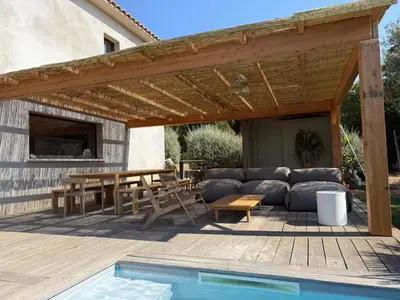 a wooden pergola with a couch and a table at Palombaggia Camara - Lecci Lodge in Lecci