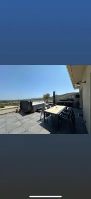 a table and benches on a building with a blue sky at Villa Mawie in Sotta