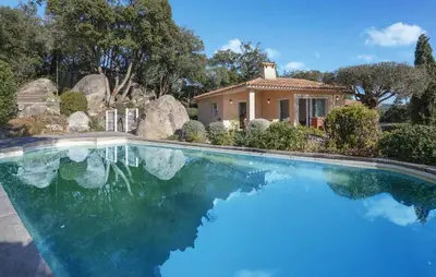 a swimming pool in front of a house at Cozy Home In Porto-Vecchio in Porto-Vecchio