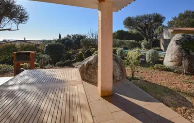 a wooden walkway with a pillar in a garden at Cozy Home In Porto-Vecchio in Porto-Vecchio