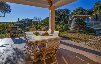 a wooden table and chairs on a patio at Cozy Home In Porto-Vecchio in Porto-Vecchio