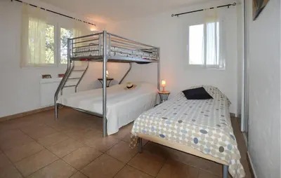 a bedroom with a bunk bed next to a bedskirts at Cozy Home In Porto-Vecchio in Porto-Vecchio