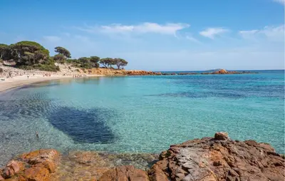 a beach with a group of people in the water at Cozy Home In Porto-Vecchio in Porto-Vecchio