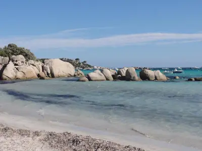 a beach with rocks in the water and the ocean at Tozzasim in Pianottoli-Caldarello
