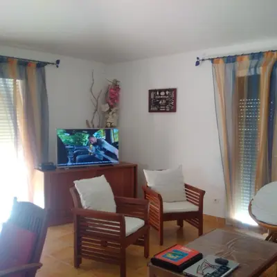 a living room with a tv and chairs and a table at Tozzasim in Pianottoli-Caldarello