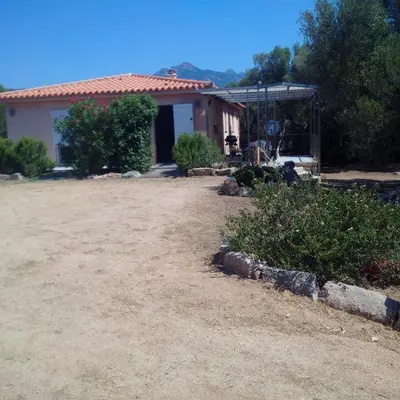a house with a dirt yard in front of it at Tozzasim in Pianottoli-Caldarello