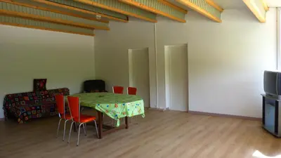 a room with a table and chairs and a television at In Tavignanu in Sortipiani