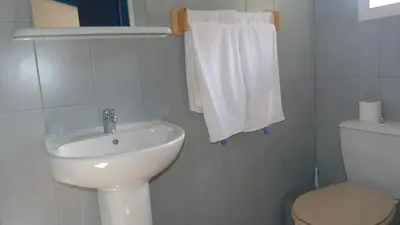 a bathroom with a sink and a toilet and towels at In Tavignanu in Sortipiani