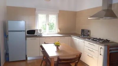 a kitchen with a table and a white refrigerator at In Tavignanu in Sortipiani