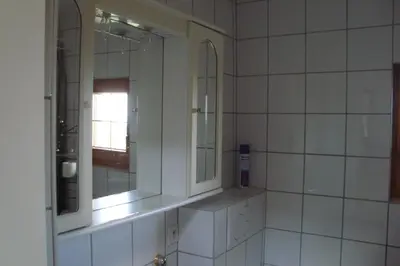 a bathroom with white tiled walls and mirrors at Kallista 1 in San-Giuliano