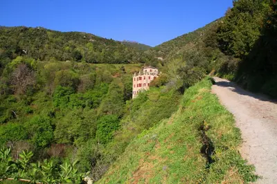 a building on a hill next to a dirt road at Kallista 1 in San-Giuliano