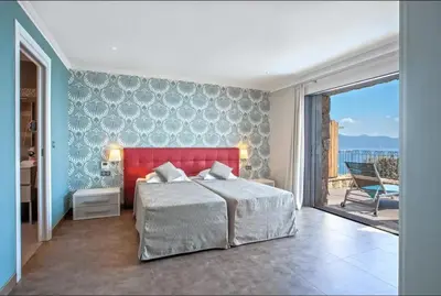 a bedroom with a red bed and a balcony at Appartement avec vue sur la mer à Olmeto in Olmeto