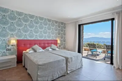 a bedroom with a large bed and a large window at Appartement avec vue sur la mer à Olmeto in Olmeto