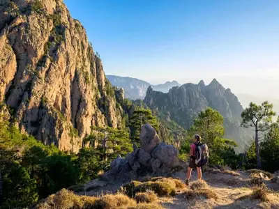 a man standing on top of a mountain at Charmante Maison de Vacances à Olmeto avec Piscine in Olmeto