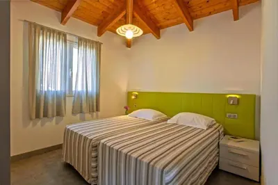 a bedroom with a large bed and a window at Charmante Maison de Vacances à Olmeto avec Piscine in Olmeto