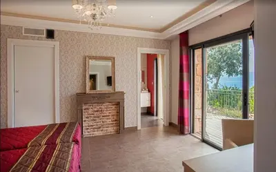 a bedroom with a bed and a fireplace and a mirror at Villa moderne avec piscine privée à Olmeto - 95 m² in Olmeto