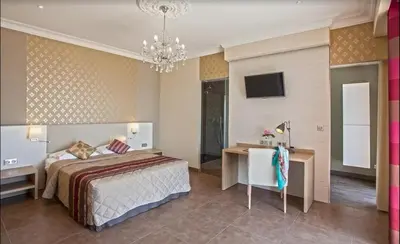 a bedroom with a bed and a desk and a television at Villa moderne avec piscine privée à Olmeto - 95 m² in Olmeto
