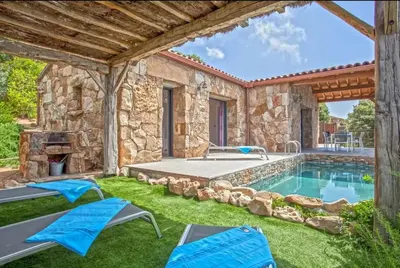 a backyard with a swimming pool and a stone house at Villa moderne avec piscine privée à Olmeto - 95 m² in Olmeto