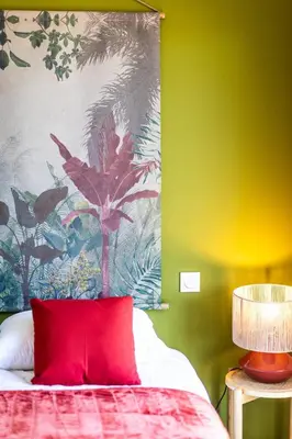 a bedroom with a red pillow and a colorful wall at Superbe mini Villa 4 à 6 personnes in Bonifacio