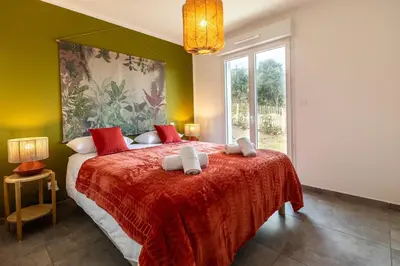 a bedroom with a large bed with a red blanket at Superbe mini Villa 4 à 6 personnes in Bonifacio