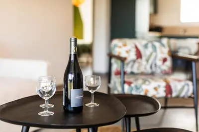 a bottle of wine sitting on a table with two glasses at Superbe mini Villa 4 à 6 personnes in Bonifacio