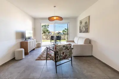 a living room with a couch and a chair at Superbe mini Villa 4 à 6 personnes in Bonifacio