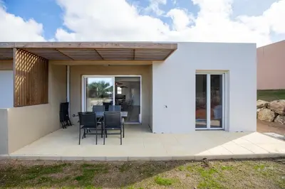 a white house with a table and chairs on a patio at Superbe mini Villa 4 à 6 personnes in Bonifacio