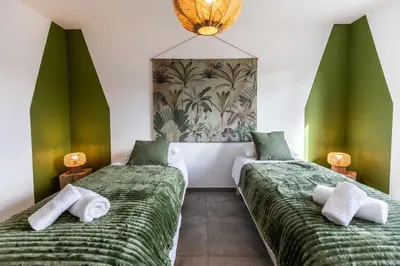 two beds in a room with green and white sheets at Superbe mini Villa 4 à 6 personnes in Bonifacio