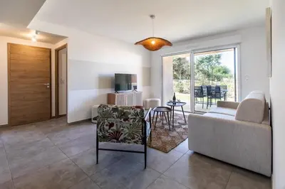 a living room with a couch and a table at Superbe mini Villa 4 à 6 personnes in Bonifacio
