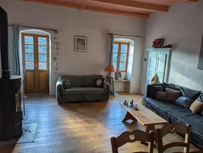 a living room with a couch and a table at Maison de charme in Pioggiola