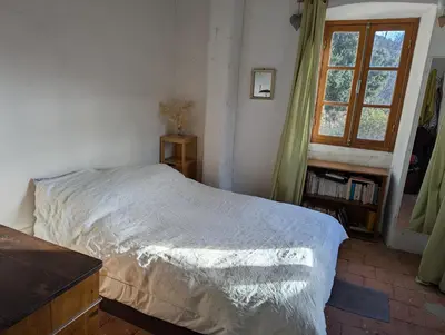 a bedroom with a bed and a window at Maison de charme in Pioggiola