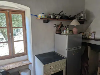 a kitchen with a stove and a refrigerator at Maison de charme in Pioggiola
