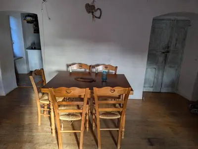 a dining room table with four chairs at Maison de charme in Pioggiola
