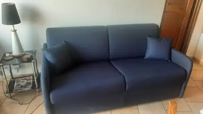a blue couch with two blue pillows on it at La Perle du Valinco #Familial#Balcon#Piscine#Mer in Propriano