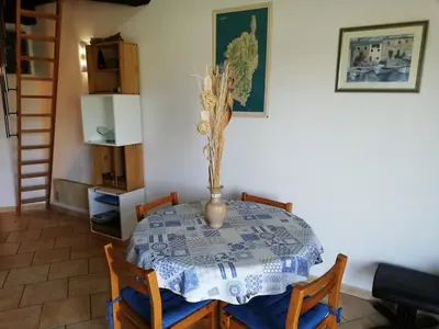 a dining room table with a vase on it at La Perle du Valinco #Familial#Balcon#Piscine#Mer in Propriano