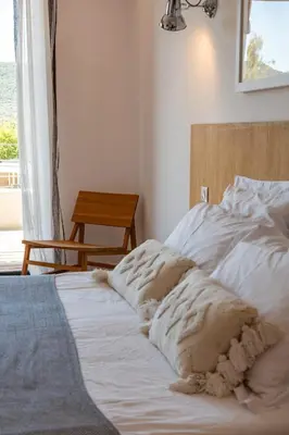 a white bed with pillows on it in a bedroom at Villa U Pinu Di Pinarellu in Pinarellu