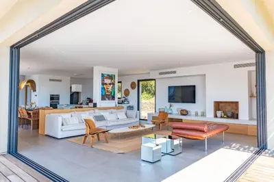 a living room with a white couch and a table at Villa U Pinu Di Pinarellu in Pinarellu