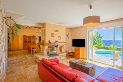 a living room with a red couch and a tv at Casa di Luiggi in Venaco