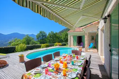 a table on a deck next to a swimming pool at Casa di Luiggi in Venaco