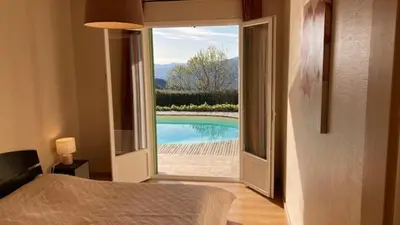 a bedroom with a view of a pool through a window at Casa di Luiggi in Venaco