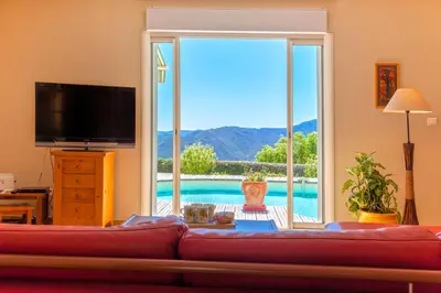 a living room with a red couch and a sliding glass door at Casa di Luiggi in Venaco