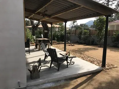 a patio with two chairs and a table under a pergola at L'Accugliente in Lecci