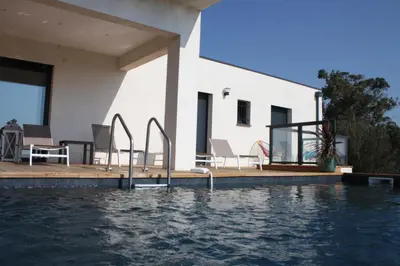 a villa with a swimming pool and a house at chambre face a la mer in Porticcio