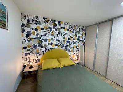 a bedroom with a bed with a flower patterned wall at Vacances de rêve à Propriano Grand appartement avec jardin Vue sur le golfe in Viggianello