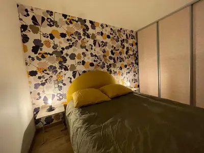 a bedroom with a bed with a flower patterned wall at Vacances de rêve à Propriano Grand appartement avec jardin Vue sur le golfe in Viggianello
