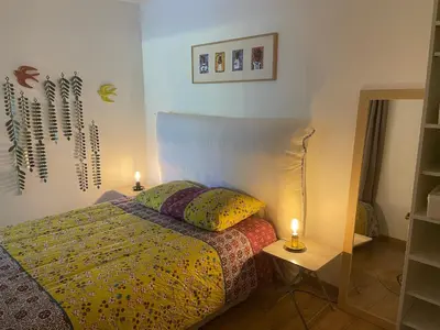 a bedroom with a bed with two lights on it at Vacances de rêve à Propriano Grand appartement avec jardin Vue sur le golfe in Viggianello